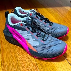Salomon tennis shoes. They are bright pink, orange, grey, and black.